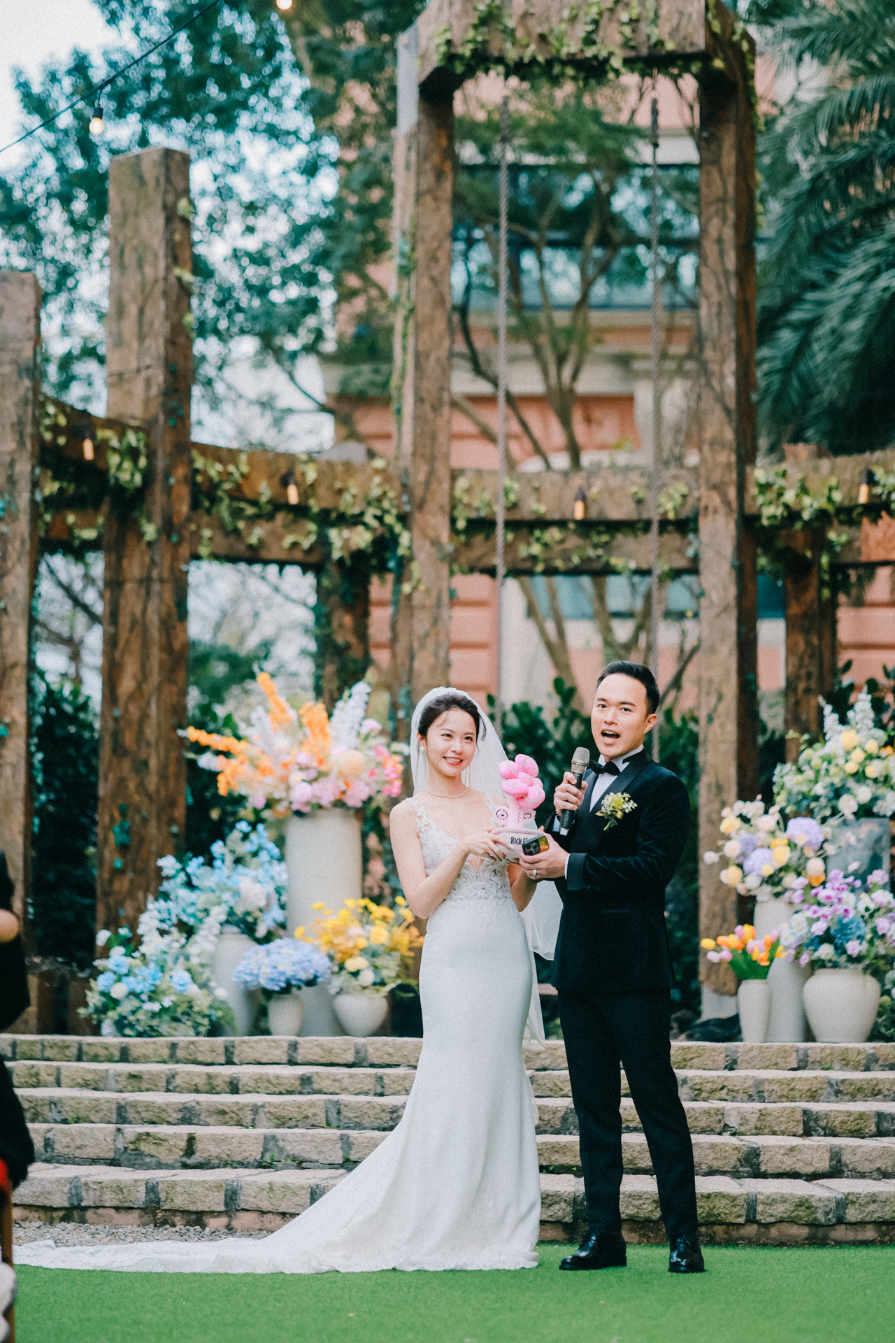 Jacob 與 Jenny 在 Chalet V 戶外證婚儀式上互動，新郎手持麥克風